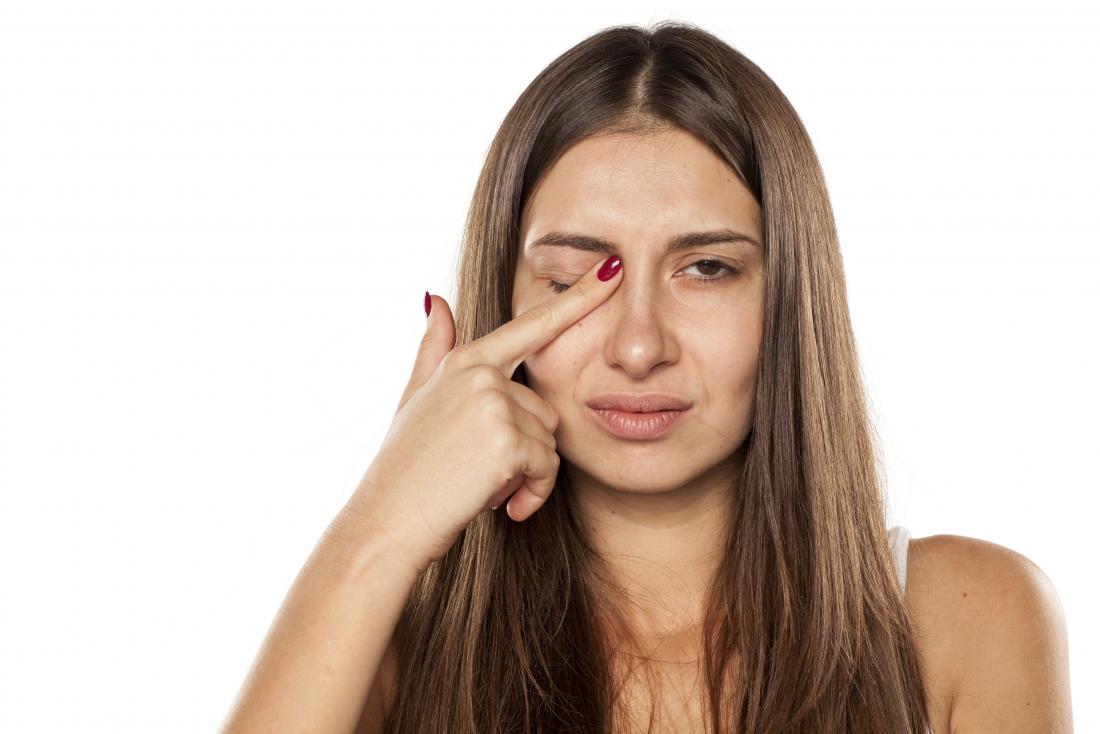 woman touching her eye